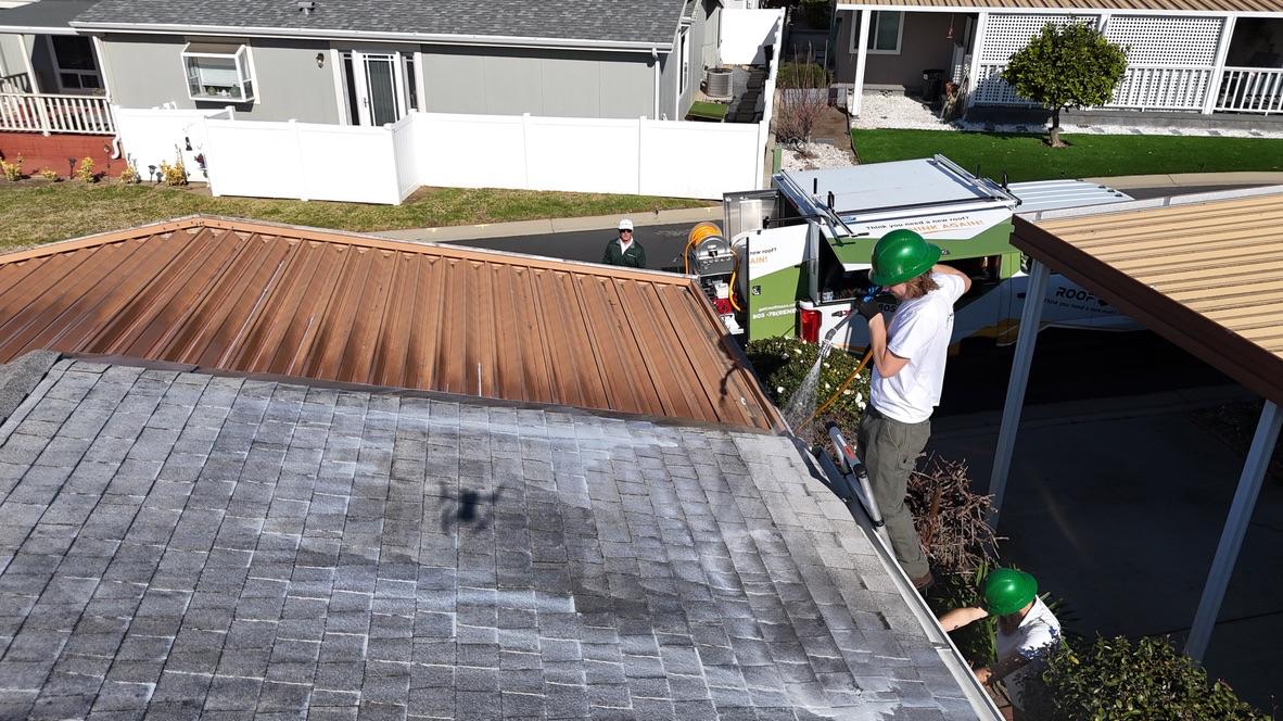 Crew spraying mobile home roof